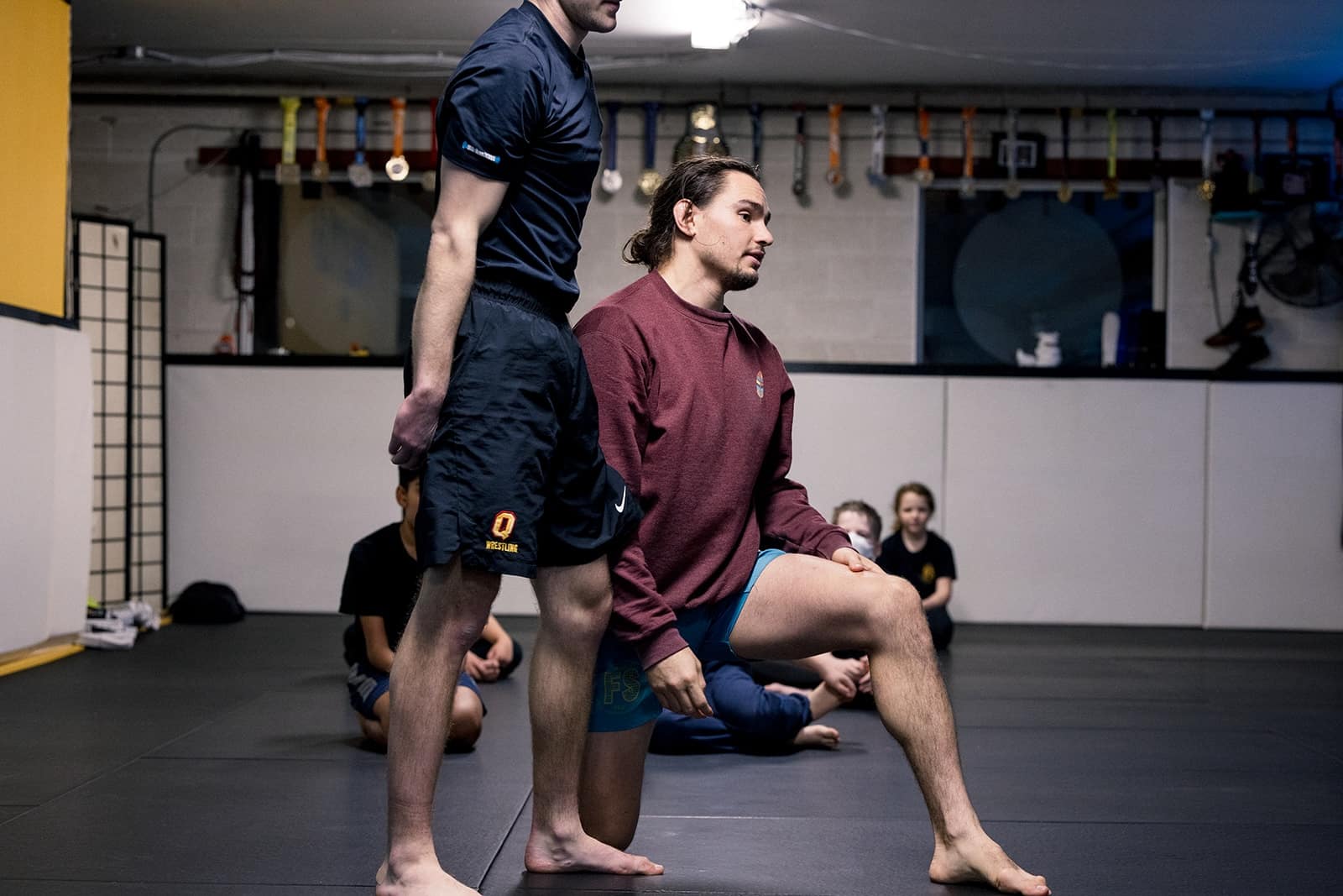 Freestyle Dojo instructor takes a knee to demonstrate bjj technique in Toronto